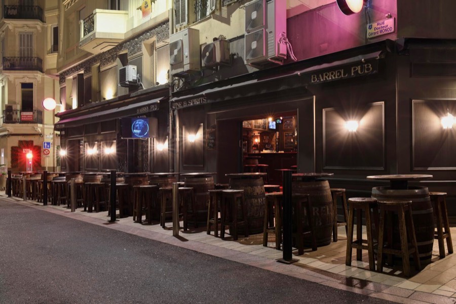 La façade du Barrel Pub la nuit, lanternes allumées sur la rue piétonne.